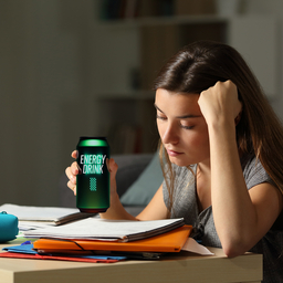 Young girl studying drinking an energy drink