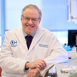 Dr. Grupp wearing a white coat in a lab