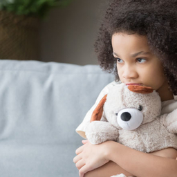 Scared young girl holding a stuffed animal