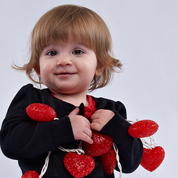 zoey holding hearts on string