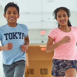 Young boy and girl running down hall