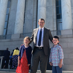 Father standing outside a courthouse with his children