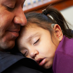 father holding sleeping daughter