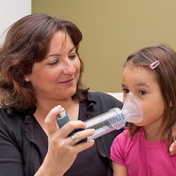 Mother helping daughter with inhaler