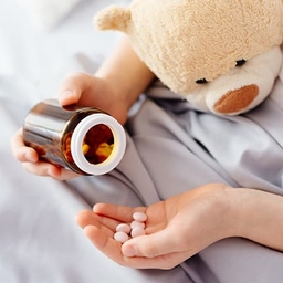 Patient's hand holding pills and bottle