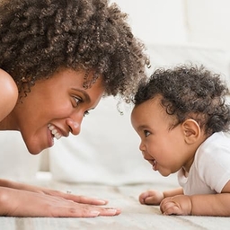 Mother playing with young toddler on the floor