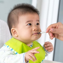 Young baby taking oral injection medicine