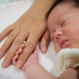 Infant holding onto finger