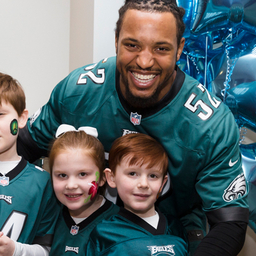 Najee Goode poses with kids at the 8th annual Huddle Up for Autism