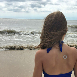 Girl on beach wearing patch