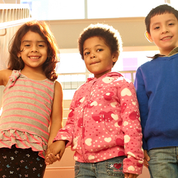 three children holding hands and smiling