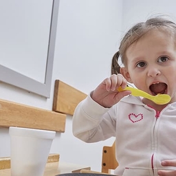 Young girl eating with a spoon