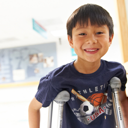 young boy with crutches