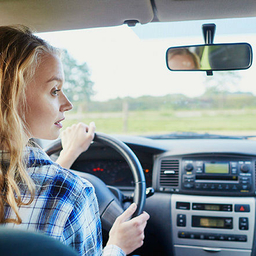 Female teenager behind the steering wheel of a car