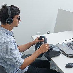 Teenager using a steering wheel for a safe driving simulator