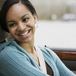 Teen girl driver in car smiling at father