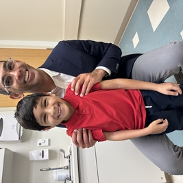 7-year-old Izahd stands with his surgeon Dr. Shah in clinic during a check up