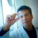 Lab technician viewing a vile with a sample