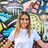 Girl in front of a colorful mural